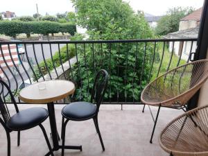 un patio con sedie e un tavolo sul balcone. di Meublés de tourisme LE TRIANON et LE PETIT TRIANON a Saint-Junien