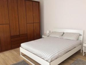 1 dormitorio con 1 cama y armario de madera en Bixio9, en La Spezia