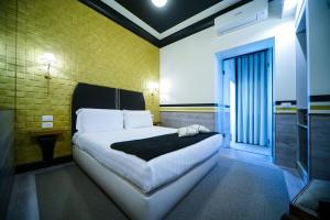 a bedroom with a bed and a yellow brick wall at Relais Luxury Corso in Rome