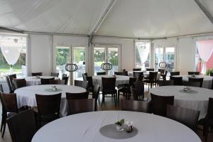 a room with white tables and chairs in a tent at Gasthof Sonnenterrasse - 24h Self-Check-in in Litzelsdorf