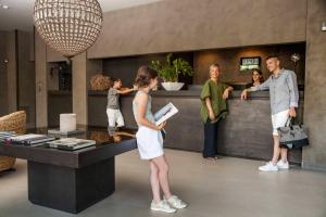 a group of people standing around a counter in a lobby at Hotel Ines in Cattolica