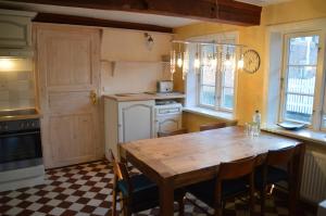 a kitchen with a wooden table and chairs at Altenteil in Oldsum