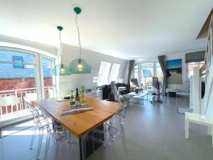 a dining room and living room with a table and chairs at Sylter Auberge im Haus Mateika in Westerland