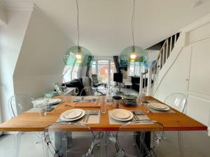 uma sala de jantar com uma grande mesa de madeira com cadeiras em Sylter Auberge im Haus Mateika em Westerland