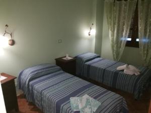 two beds in a hotel room with at B&B Mony e Nico in Riola Sardo