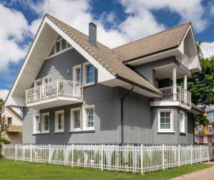 a house with a white fence in front of it at Smėlynas Boutique & SPA in Palanga