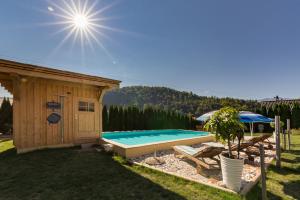 un patio trasero con piscina al lado de un edificio en Apartmaji pri Jožu, en Bohinj