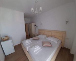 a bedroom with a large white bed with two pillows at Vogklis House in Qeparo
