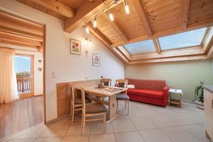 ein Wohnzimmer mit einem roten Sofa und einem Tisch in der Unterkunft Tonigbauernhof Enzian in Schenna