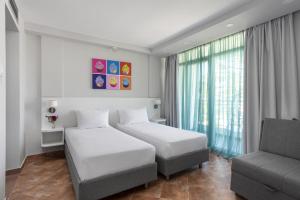 a hotel room with two beds and a couch at Azul Beach Resort Montenegro by Karisma - All Inclusive in Ulcinj