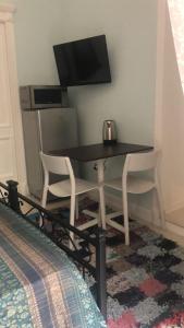 uma mesa de jantar com 2 cadeiras e uma televisão em La stanza di Zeza em Nápoles