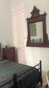 um quarto com uma cama e um espelho na parede em La stanza di Zeza em Nápoles