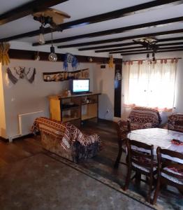 a living room with a table and a tv at Cabana NEDA in Rausor