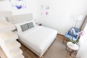 a bedroom with a white bed and a blue chair at Azul Beach Resort Montenegro by Karisma - All Inclusive in Ulcinj