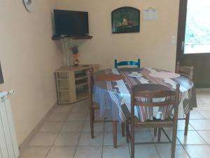 una cucina con tavolo, sedie e TV di les lavandes a Montjay