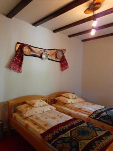 two beds in a room with a head board on the wall at Cabana NEDA in Rausor