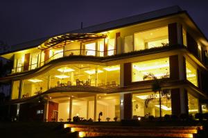 un grande edificio con molte finestre di notte di LakeRose Wayanad Resort - Lake view a Kalpetta Altre 2 foto