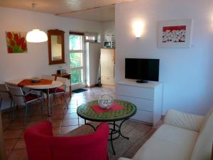 a living room with a tv and a table and chairs at Landhaus-Marwede App 4 in Haffkrug