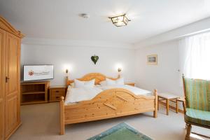 1 dormitorio con 1 cama grande de madera y TV en Gästehaus Prinzregent Luitpold, en Bad Steben