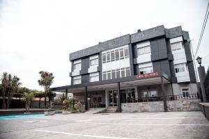 a building with a parking lot in front of it at Hotel Los Olmos in Lugo