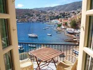 a view of a harbor from a balcony with a table and chairs at Marina Studios in Symi