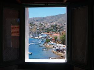 ein Fenster mit Blick auf einen Hafen mit Booten in der Unterkunft Marina Studios in Symi