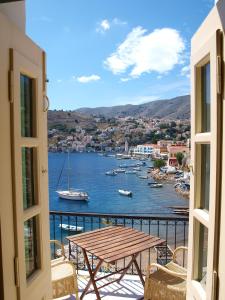 a balcony with a table and a view of a harbor at Marina Studios in Symi