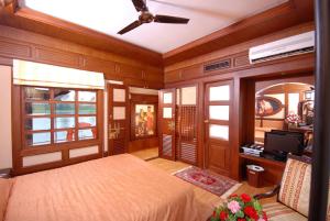 a bedroom with a bed and a ceiling fan at Sterling Houseboats Lake Palace, Alleppey in Alleppey