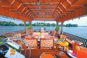 a restaurant on a boat on the water at Sterling Houseboats Lake Palace, Alleppey in Alleppey