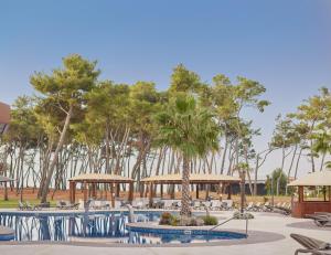 a resort with tables and chairs and trees at Azul Beach Resort Montenegro by Karisma - All Inclusive in Ulcinj