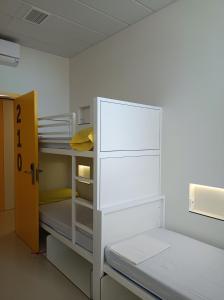 巴塞隆納的住宿－Alberg Barcelona Xanascat，一间设有一张双层床的客房,位于带门的房间