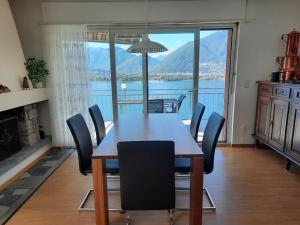 a dining room table and chairs with a view of the water at Casa Montana in San Nazzaro