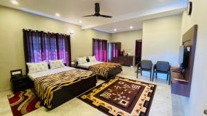 1 dormitorio con 2 camas, mesa y sillas en RR Holidays en Kodaikānāl