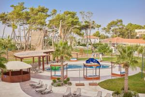 a park with a playground with chairs and a slide at Azul Beach Resort Montenegro by Karisma - All Inclusive in Ulcinj