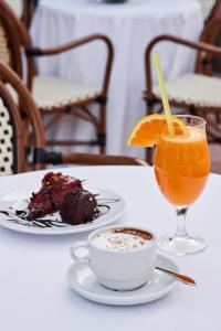 a table with two plates of food and a drink at Azul Beach Resort Montenegro by Karisma - All Inclusive in Ulcinj