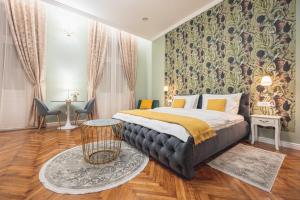 1 dormitorio con 1 cama grande y papel pintado con motivos florales en Central Park Rooms, en Oradea
