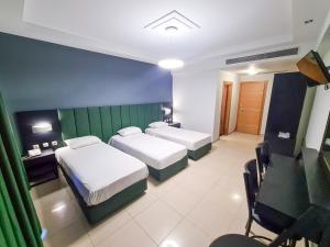 een hotelkamer met 2 bedden en een bureau bij Perinthos Hotel in Anchialos