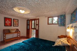 um quarto com uma cama azul e uma janela em Auberge le Maquis em Aghbalou
