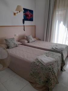 a bedroom with two beds and a lamp at Hostal Alhambra Tarragona in Tarragona
