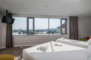 um quarto de hotel com duas camas e uma grande janela em B&B Hotel Budapest City em Budapeste