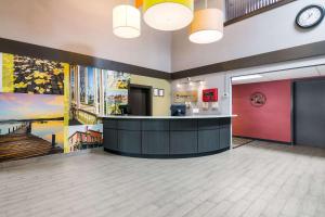 a lobby with a waiting area with a clock on the wall at Clarion Pointe Jamestown - Falconer in Jamestown