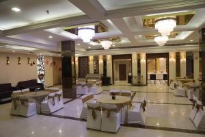 a banquet hall with tables and chairs in a building at Hotel S C Residency in Zirakpur