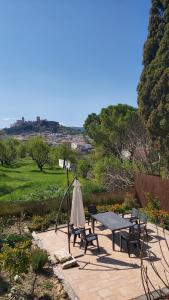 eine Terrasse mit einem Tisch, Stühlen und einem Sonnenschirm in der Unterkunft Cauchil Chico in Alcalá la Real