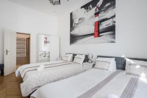 2 camas en un dormitorio con un faro rojo en la pared en Real Apartments Vadász, en Budapest