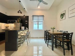 a dining room and kitchen with a table and chairs at Spacious Home with Private Swimming Pool in Langkawi by Zervin in Kuah