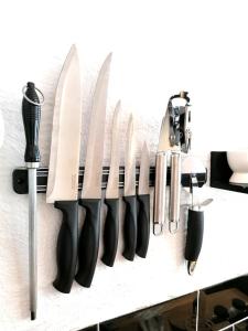 a row of knives hanging on a wall at The Old Smithy in Trefriw