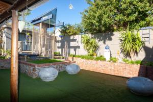 a building with a lawn with spheres on it at Strand Double En-Suite Studio in Cape Town +7 photos