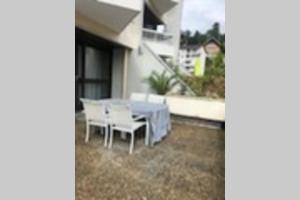 - une table et des chaises sur la terrasse d'une maison dans l'établissement T2 grande terrasse Wi-Fi parking gratuit, à Voiron