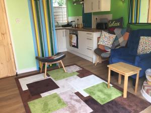 a living room with a blue couch and a kitchen at The Barn in South Hayling