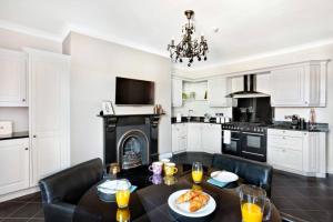 een keuken met een tafel en stoelen en een open haard bij Central Harrogate townhouse apartment with parking in Harrogate